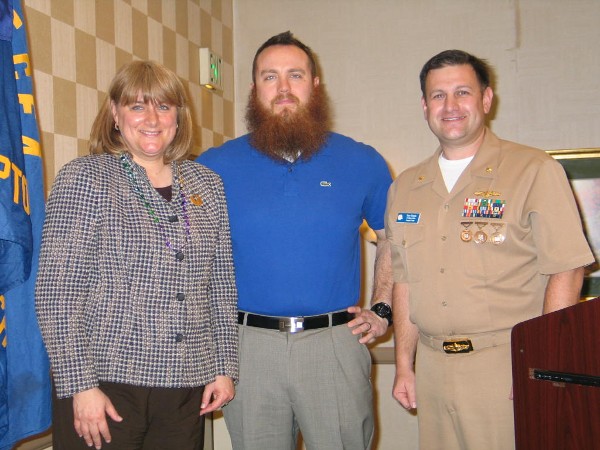 Duvall presents the February Civilian Cyber Professional Award to Brian Cooke, Navy Continuous Training Environment, Naval Warfare Development Command, while Cmdr. Pereira stands witness.